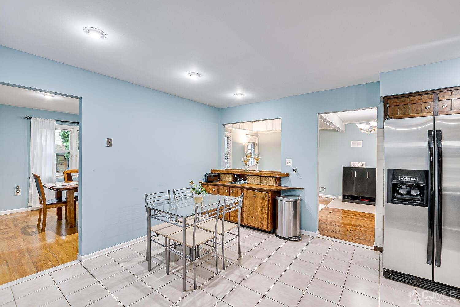 937 New Dover Road Edison, NJ 08820 - Photo 16 of 51 a kitchen with stainless steel appliances kitchen island granite countertop a refrigerator a stove a dining table and chairs with wooden floor