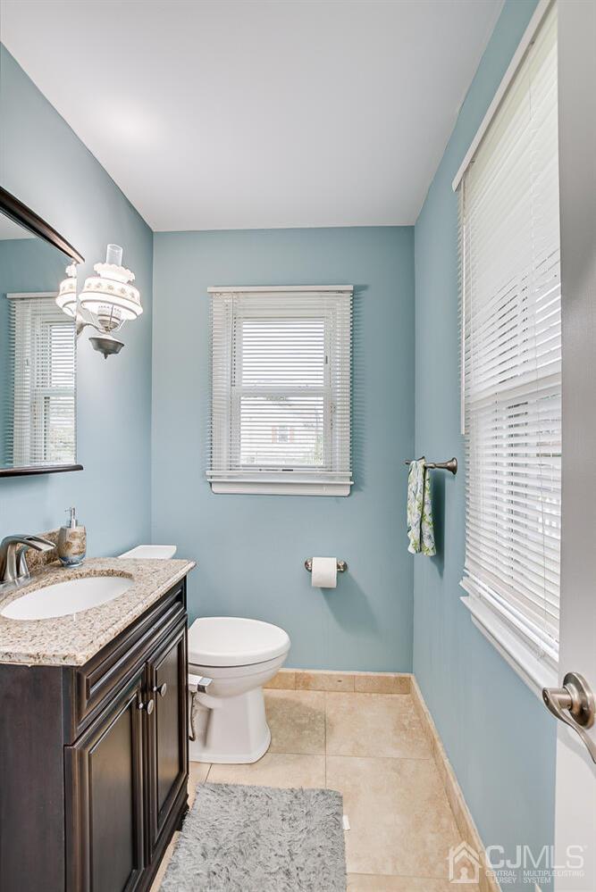 937 New Dover Road Edison, NJ 08820 - Photo 26 of 51 a spacious bathroom with a granite countertop sink a toilet a mirror and a window