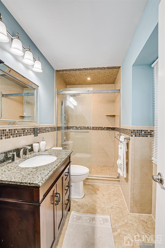 937 New Dover Road Edison, NJ 08820 - Photo 31 of 51 a bathroom with a granite countertop sink a toilet and a mirror