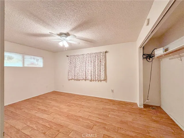 an empty room with windows and fan