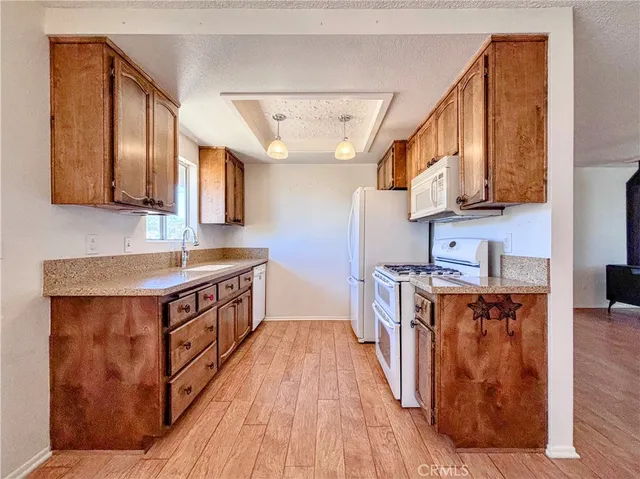 a kitchen with stainless steel appliances granite countertop a stove a sink and a wooden floors