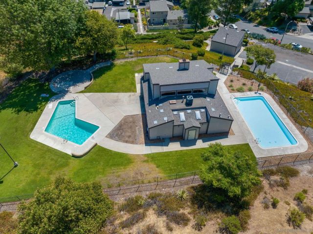 a view of a swimming pool with a yard and trees
