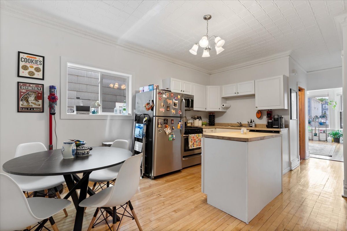 2735 North Ridgeway Avenue Chicago, IL 60647 - Photo 23 of 40 a kitchen with a dining table chairs refrigerator and cabinets