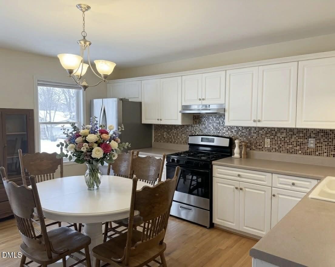 609 Shambley Road Mebane, NC 27302 - Photo 3 of 17 a kitchen with stainless steel appliances a dining table chairs and granite counter tops