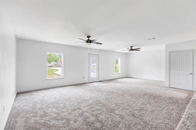 a view of a big room with windows and chandelier fan