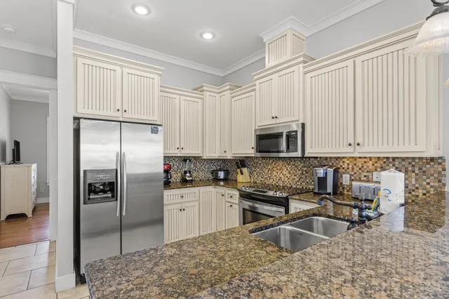 a kitchen with stainless steel appliances granite countertop a sink a stove and a refrigerator