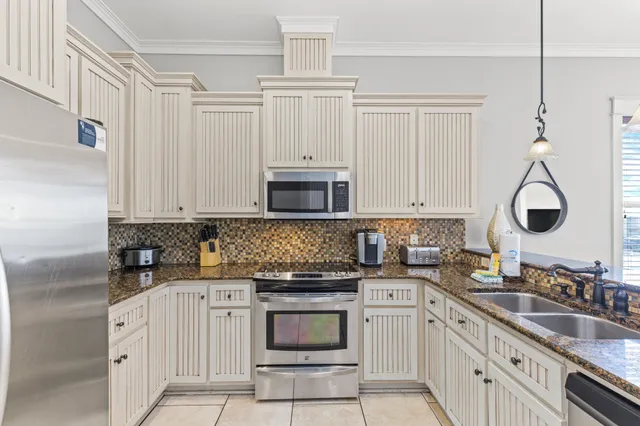 a kitchen with granite countertop a sink stainless steel appliances and cabinets