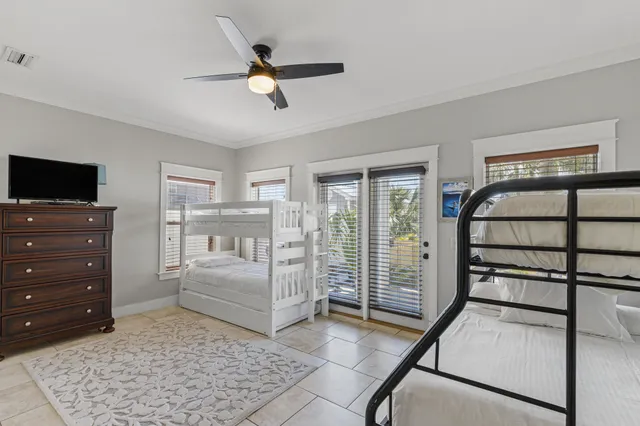 a bedroom with a bed a flat screen tv and couches