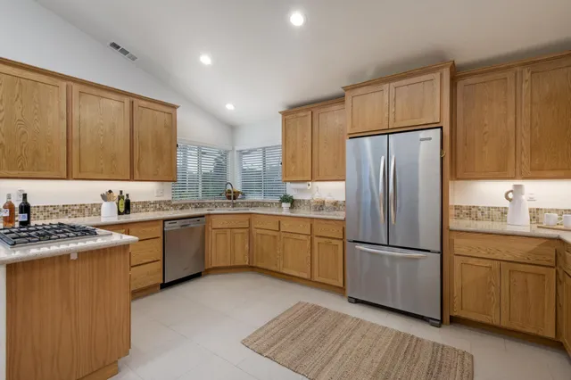 a kitchen with a refrigerator sink and cabinets
