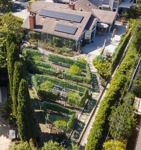 an aerial view of a house with a yard lake and outdoor seating