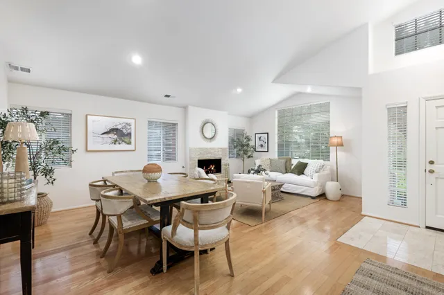 a living room with fireplace furniture and a large window