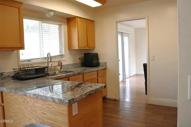a kitchen with granite countertop a sink and a stove top oven