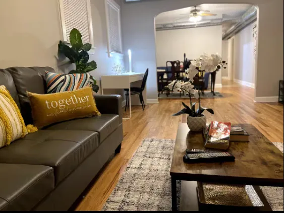 a living room with furniture and a wooden floor