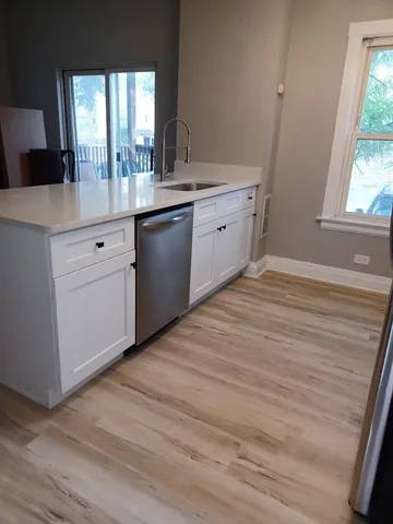 a room with a sink cabinets and a wooden floor