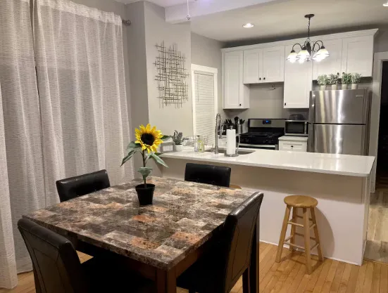 a kitchen with a table chairs refrigerator and microwave