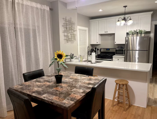 217 Des Plaines Avenue, Unit 1 Forest Park, IL 60130 - Photo 10 of 15 a kitchen with a table chairs refrigerator and microwave