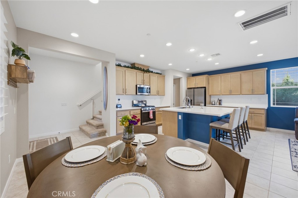 32736 Brunello Way Temecula, CA 92591 - Photo 38 of 75 a kitchen with granite countertop lots of white appliances a dining table and chairs