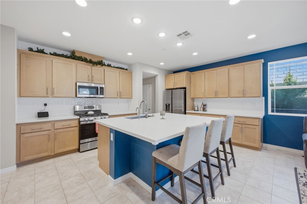 32736 Brunello Way Temecula, CA 92591 - Photo 40 of 75 a kitchen with stainless steel appliances granite countertop a table chairs sink refrigerator and cabinets
