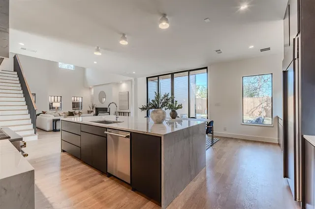 a kitchen with stainless steel appliances granite countertop a sink stove and wooden floor