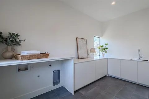 a hallway with white cabinets and potted plant