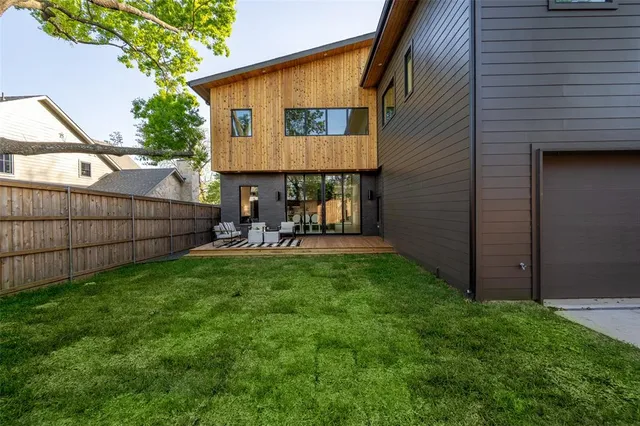 a view of backyard with outdoor seating and wooden fence