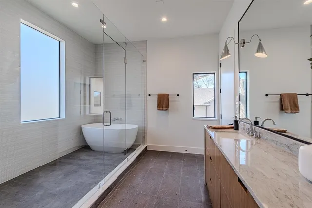 a bathroom with a granite countertop sink and a bathtub