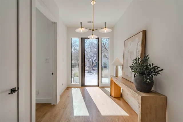 a room with chandelier and wooden floor