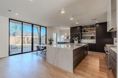 a large kitchen with stainless steel appliances granite countertop a large center island and a stove in it