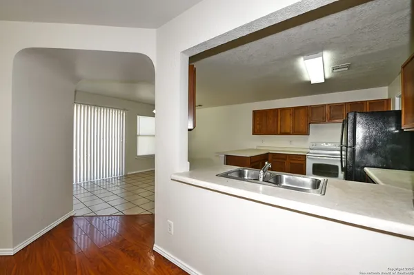 a kitchen with kitchen island a sink and a large mirror next to a window