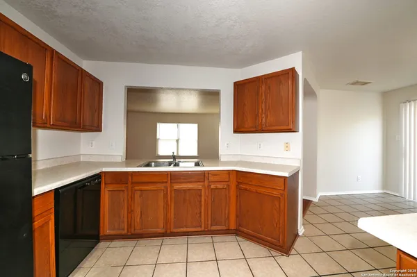 a kitchen with a sink window and cabinets