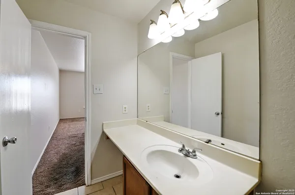 a bathroom with a sink a light fixture and a mirror