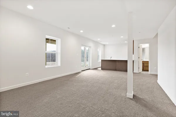 an empty room with a window and a kitchen