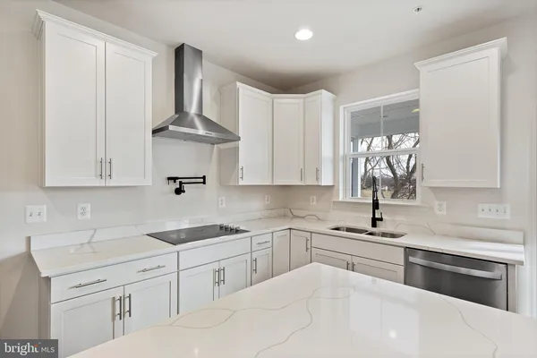 a kitchen with white cabinets appliances and sink