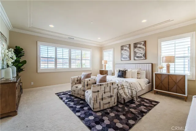 a bedroom with a large bed a potted plant and a window