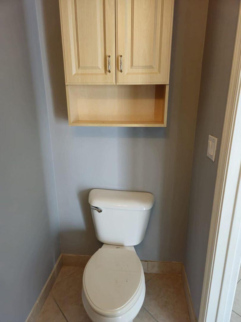 3123 Grandiflora Drive Greenacres, FL 33467 - Photo 15 of 49 a bathroom with a toilet sink and mirror