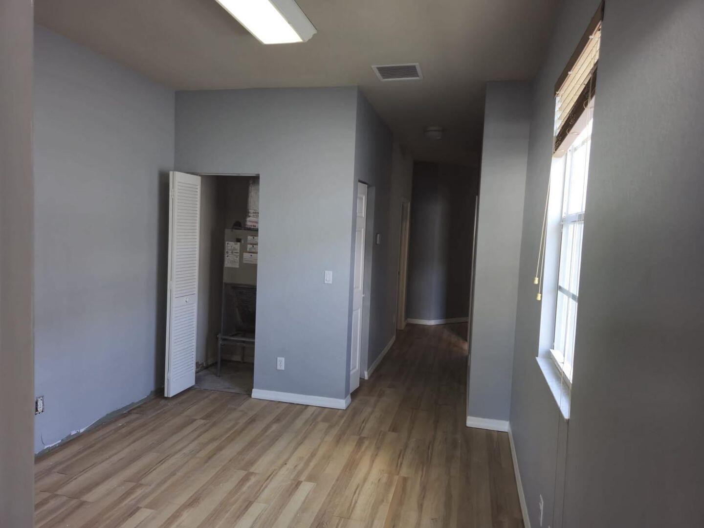 3123 Grandiflora Drive Greenacres, FL 33467 - Photo 21 of 49 an empty room with wooden floor and windows