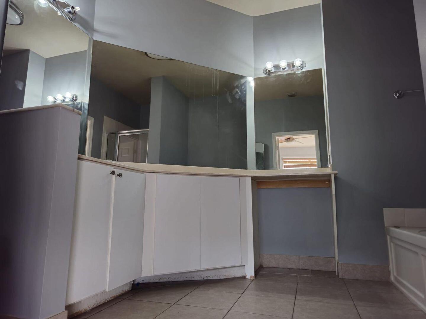 3123 Grandiflora Drive Greenacres, FL 33467 - Photo 24 of 49 a bathroom with a mirror and a sink