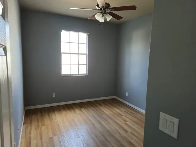 a view of an empty room with wooden floor