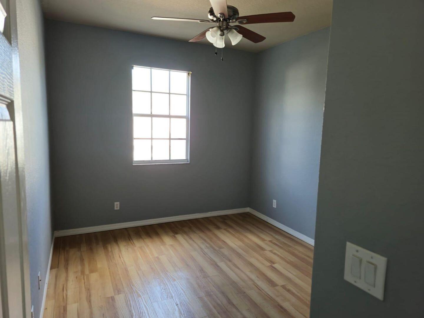 3123 Grandiflora Drive Greenacres, FL 33467 - Photo 32 of 49 an empty room with wooden floor windows and fan