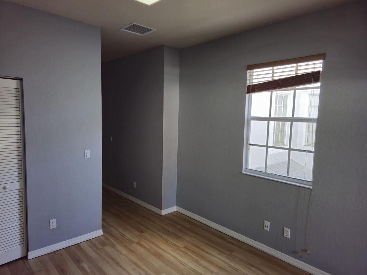 3123 Grandiflora Drive Greenacres, FL 33467 - Photo 36 of 49 an empty room with wooden floor and windows