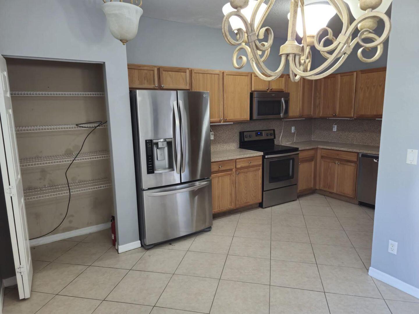 3123 Grandiflora Drive Greenacres, FL 33467 - Photo 7 of 49 a kitchen with stainless steel appliances granite countertop a refrigerator and a sink