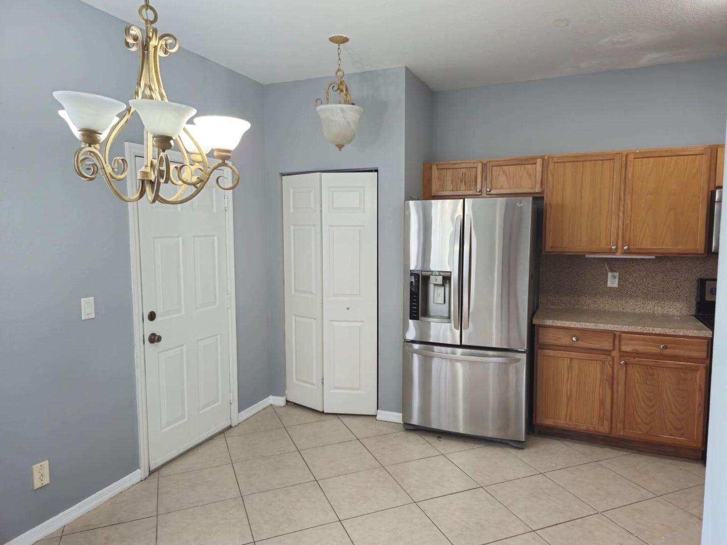 3123 Grandiflora Drive Greenacres, FL 33467 - Photo 10 of 49 a kitchen with a refrigerator and cabinets