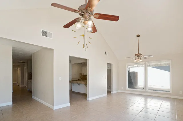 a view of an empty room with a fireplace and a window