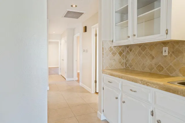 a view of a swimming pool with a lawn chairs under palm trees