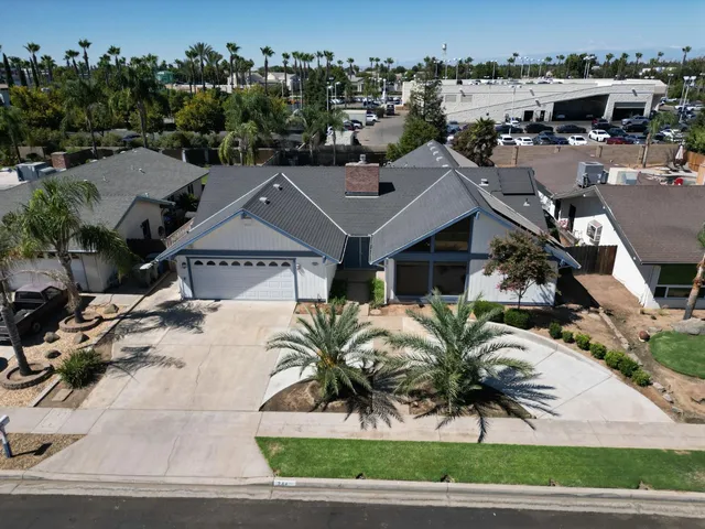 an aerial view of a house with a garden and mountain view in back