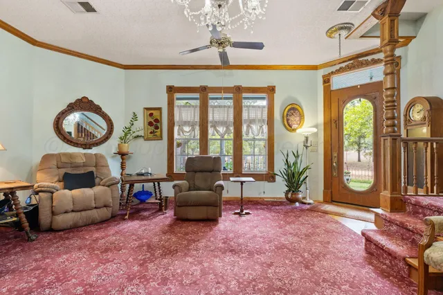 a living room with furniture a chandelier and a fireplace