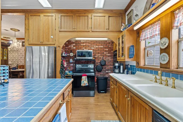 a kitchen with a table chairs refrigerator and a sink