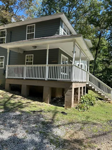 a view of a house with a yard and deck