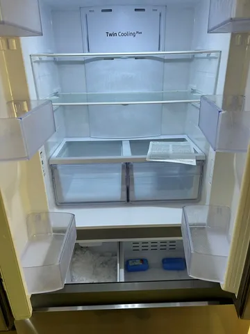 a view of a kitchen with refrigerator and white cabinets
