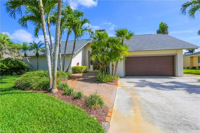 a front view of a house with a yard and a garage